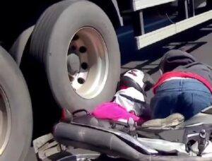 motociclista-tenta-ultrapassar-entre-dois-caminhoes-e-casal-cai-mulher-e-atingida-nas-costas-pelo-pneu
